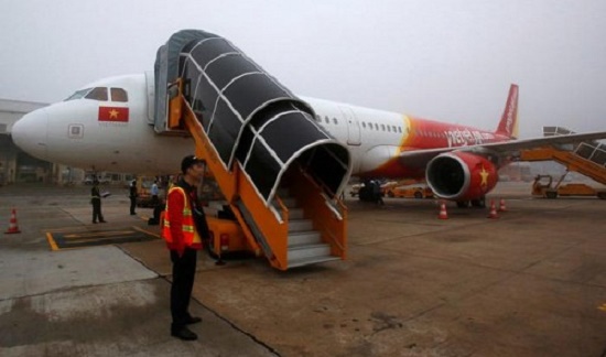 A security officer stands next to a VietJet aircraft at Noi Bai International airport in Hanoi, Vietnam, January 10, 2017. Reuters