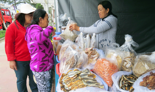 Người dân ghé các gian hàng bán sản phẩm chế biến từ hải sản mua chút quà đầu năm.