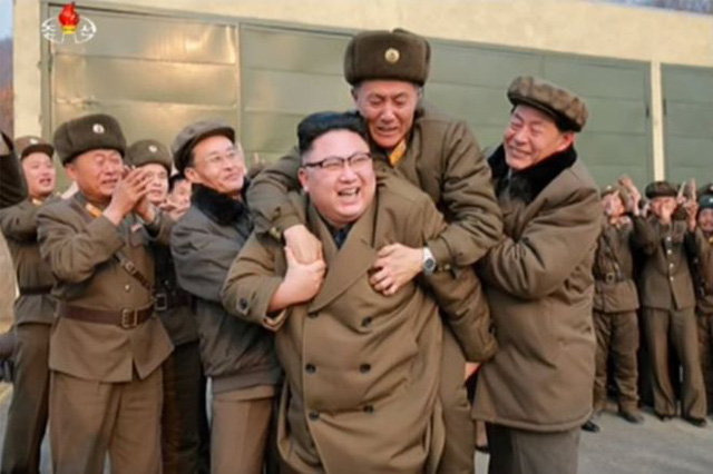 Bức ảnh chụp nhà lãnh đạo Kim Jong-un vui vẻ cõng một người đàn ông trên lưng (Ảnh: KCNA)