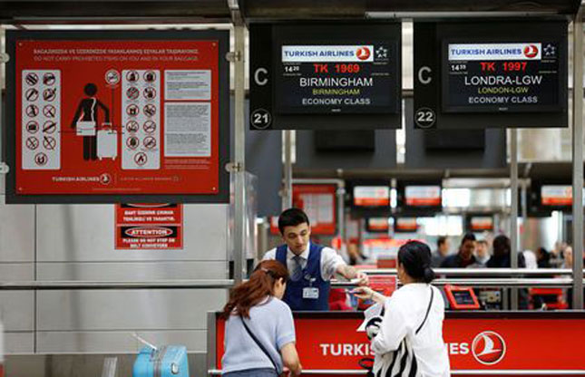 Hành khách làm thủ tục trong chuyến bay của hãng Turkish Airlines đến Mỹ tại sân bay quốc tế Ataturk ở Istanbul, Thổ Nhĩ Kỳ. 						    	       Ảnh: Reuters