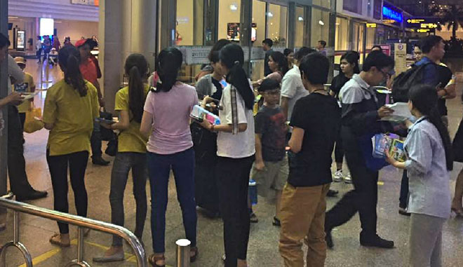 Nhân viên phát tờ rơi (đa phần là sinh viên) xếp hàng chờ tại cửa ra sân bay để đưa tờ rơi cho du khách. Ảnh: FB Hồ Thị Vân đăng trên trang mạng xã hội.
