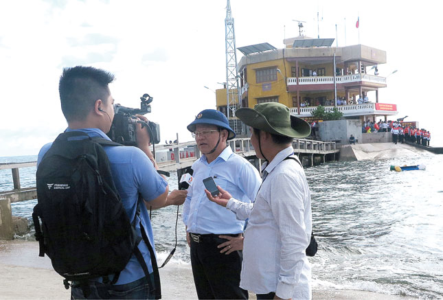 Phó Bí thư Thường trực Thành ủy Võ Công Trí (giữa) trả lời phỏng vấn báo chí khi thăm đảo Thuyền Chài. Ảnh: SƠN TRUNG