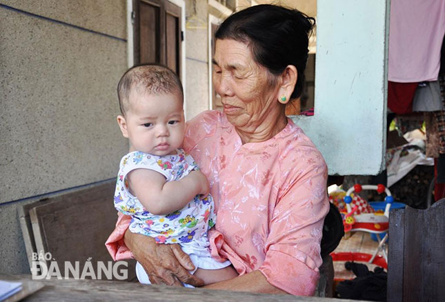 Chương trình nâng cao mức sống gia đình chính sách luôn được quận Sơn Trà tập trung triển khai. Trong ảnh: Bà Nguyễn Thị Sáo chăm sóc cháu để các con tranh thủ đi làm có thêm thu nhập.