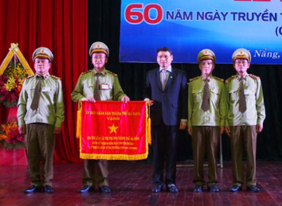 Phó Chủ tịch UBND thành phố Hồ Kỳ Minh tặng cờ truyền thống cho lực lượng QLTT Đà Nẵng nhân kỷ niệm 60 năm thành lập ngành. 				                             Ảnh: DUYÊN ANH