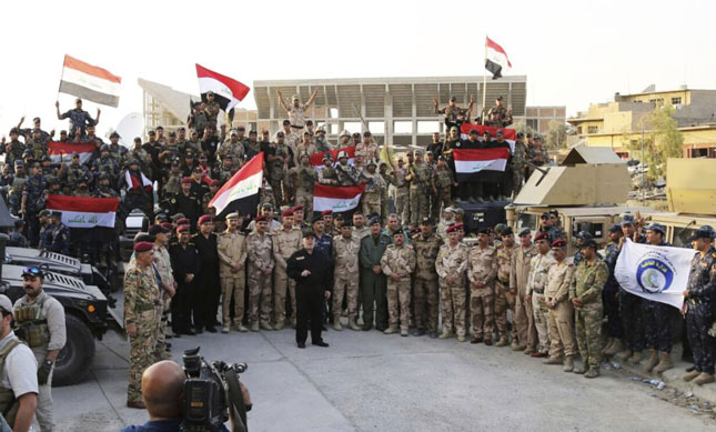 Đứng giữa lực lượng an ninh ở Mosul, Thủ tướng Iraq Haider al-Abadi tuyên bố chiến thắng, chấm dứt sự chiếm đóng của IS ở thành phố này.  			        Ảnh: AP