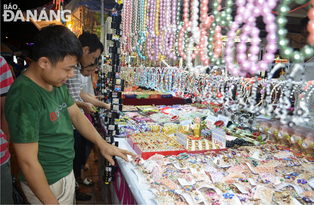 Chợ đêm sẽ góp phần thu hút và giữ chân khách du lịch đến với Đà Nẵng. Trong ảnh: Khách tham quan, mua sắm tại các gian hàng ở Công viên Biển Đông dịp Điểm hẹn mùa hè 2017.