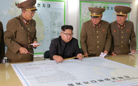 Lãnh đạo Triều Tiên Kim Jong-un (giữa) lắng nghe các tướng lĩnh trình bày kế hoạch tấn công đảo Guam. Ảnh: KCNA