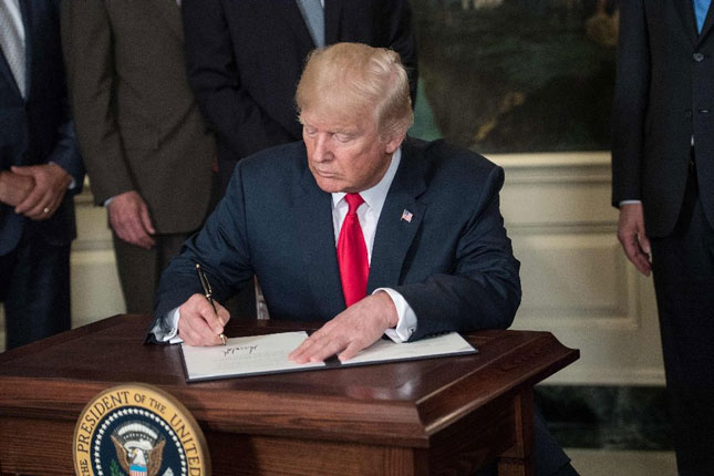 Tổng thống Mỹ Donald Trump ký sắc lệnh điều tra hoạt động thương mại của Trung Quốc.  Ảnh: AFP