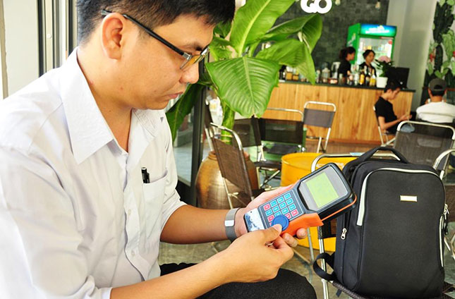 Thạc sĩ Trần Lê Thăng Đồng giới thiệu thiết bị cấp phiếu giữ xe cầm tay sử dụng công nghệ RFID do chính anh sáng tạo.