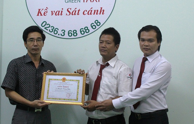 Deputy Director Cuong (left) presenting a Certificate of Merit to taxi driver Hieu (centre)