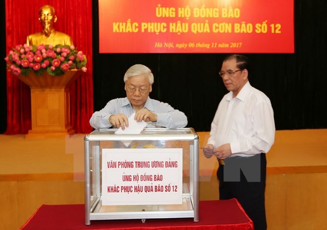 Tổng Bí thư Nguyễn Phú Trọng và nguyên Tổng Bí thư Nông Đức Mạnh tham gia quyên góp ủng hộ đồng bào khắc phục hậu quả thiên tai. (Ảnh: Trí Dũng/TTXVN)