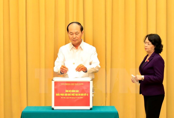 Chủ tịch nước Trần Đại Quang và Phó Chủ tịch nước Đặng Thị Ngọc Thịnh tham gia quyên góp ủng hộ đồng bào các tỉnh Nam Trung Bộ bị ảnh hưởng nặng nề do cơn bão số 12 gây ra. (Ảnh: Nhan Sáng/TTXVN)