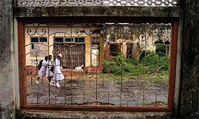 Trẻ em đi qua khu phố vẫn còn đổ nát ở Sri Lanka.