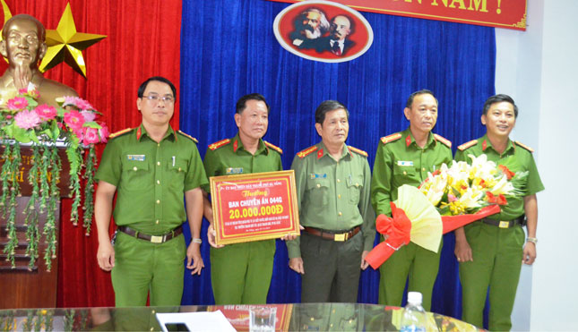 Đại tá Lê Văn Tam (giữa), trao 20 triệu đồng của UBND thành phố thưởng Ban chuyên án 044G.