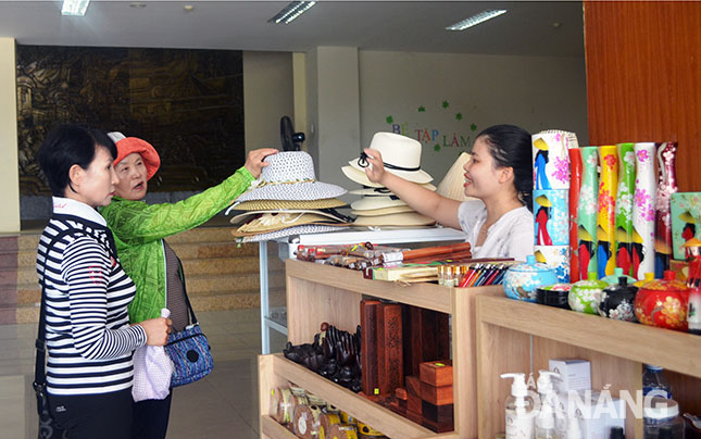 Đà Nẵng vẫn thiếu những sản phẩm lưu niệm mang tính đặc trưng của địa phương.  Trong ảnh: Khách quốc tế mua sắm tại Bảo tàng Đà Nẵng.  