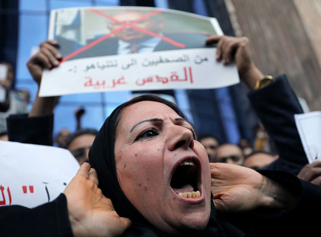 Người dân Ai Cập biểu tình phản đối việc ông Trump công nhận Jerusalem là thủ đô của Israel. Trong ảnh: Những người biểu tình giăng biểu ngữ lên án Tổng thống Ai Cập Abdel Fattah el-Sisi và Tổng thống Mỹ Donald Trump. 		                 		                Ảnh: Reuters