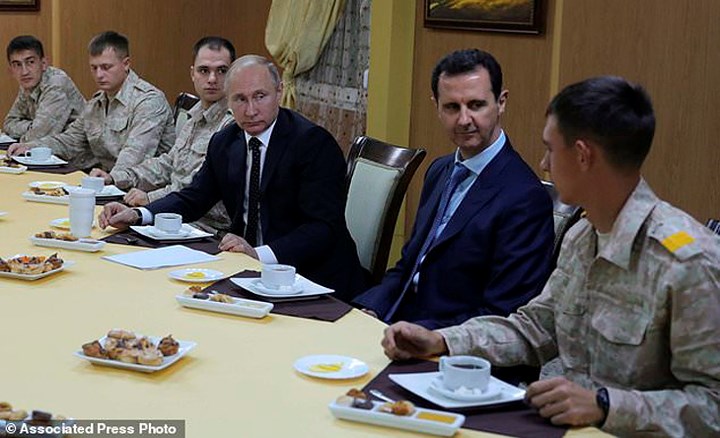   Tổng thống Nga cùng người đồng cấp Syria dùng bữa với các binh sĩ làm nhiệm vụ tại căn cứ Hmeimim. Ảnh: AP.