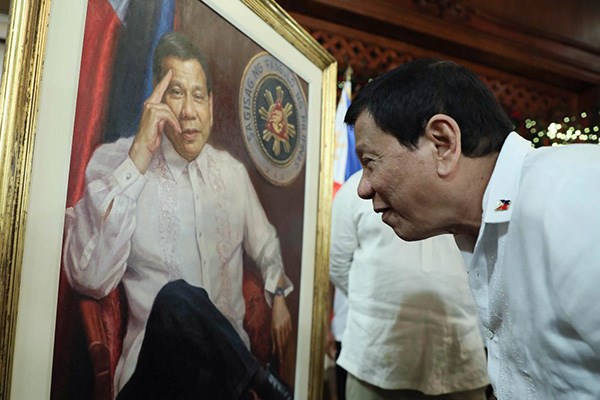 President Rodrigo Roa Duterte takes time to appreciate the painting of his portrait which was presented to him in Malacañan Palace on December 5, 2017 (Source: philstar.com)