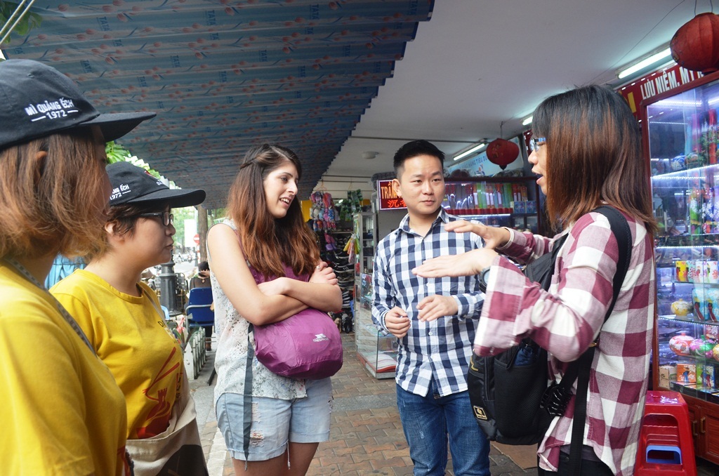 Loi (2nd right), along with volunteer tour guides (1st and 2nd left) chatting with visitors at the Han Market 