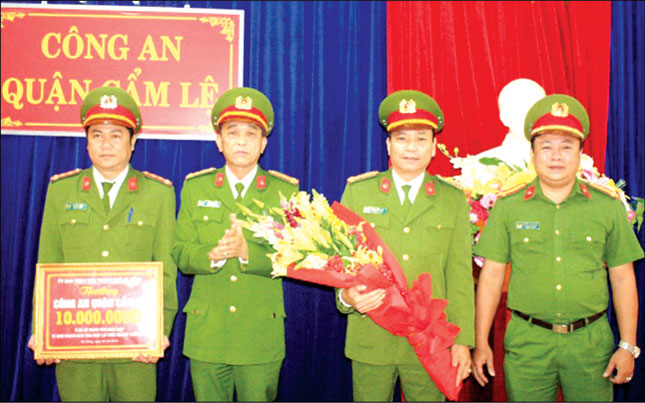 Đại tá Trần Mưu (thứ 2, trái sang) trao tiền thưởng của Chủ tịch UBND thành phố cho Công an quận Cẩm Lệ.