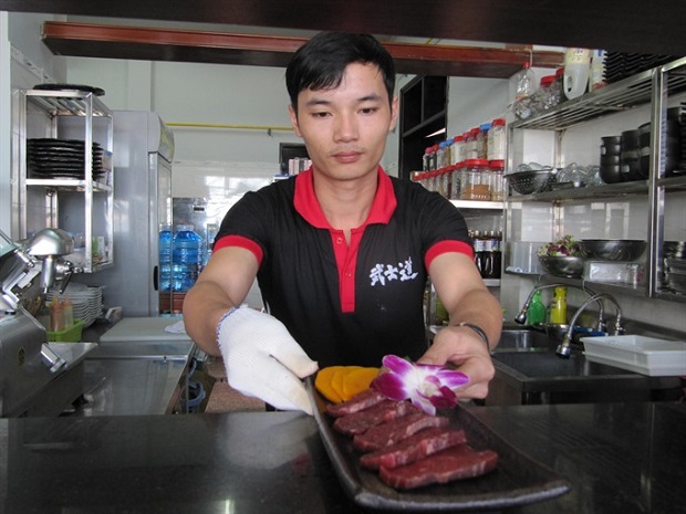 A worker at a Japanese restaurant serves a dish. The central city of Đà Nẵng needs 20,000 workers in tourism by 2020. — VNS Photo Công Thành Read more at http://vietnamnews.vn/society/422378/deal-on-training-in-hospitality-inked.html#lQvlTP0O2HXst2HS.99