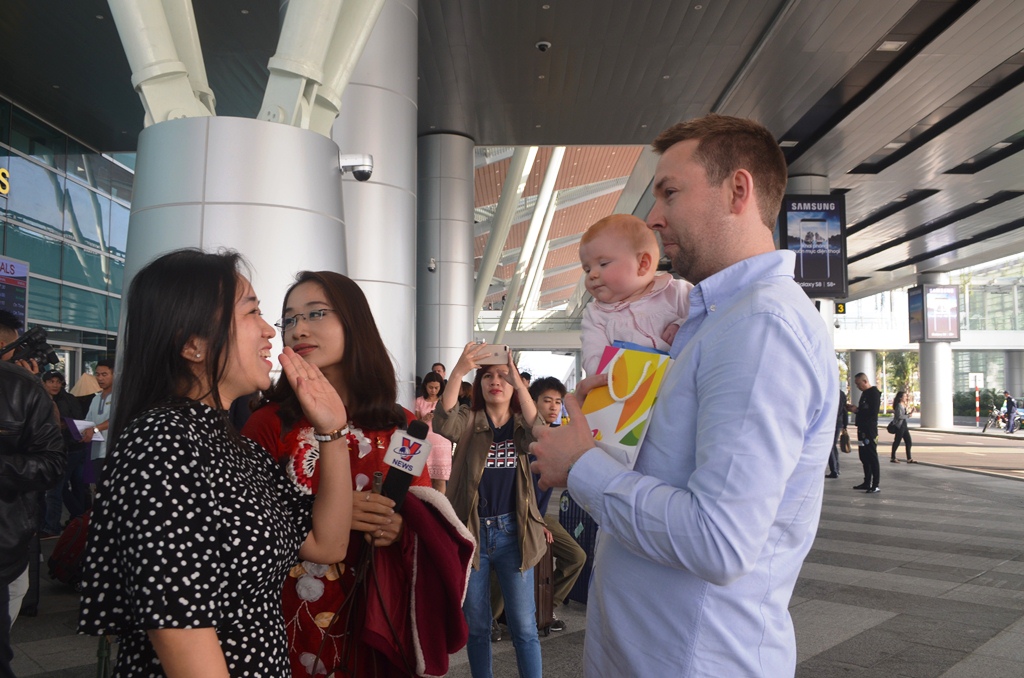 Gia đình anh Ross HellAby (phải), quốc tịch Anh Quốc không giấu được niềm vui khi được chào đón rộn ràng dịp tết cổ truyền tại Cảng hàng không quốc tế Đà Nẵng.
