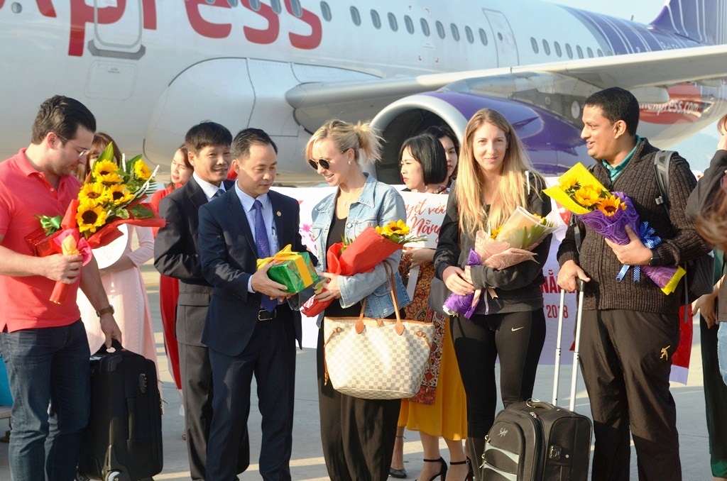 Vice Director Binh (2nd left) presenting flowers and gifts to first international passengers