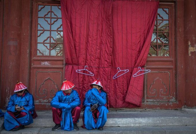 Các nghệ sĩ Trung Quốc mặc trang phục thời nhà Thanh đang nghỉ ngơi trong giờ giải lao của buổi tổng duyệt chương trình chào năm mới ở thủ đô Bắc Kinh.