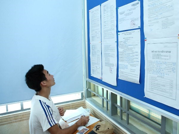 Thí sinh xem thủ tục làm hồ sơ xét tuyển vào đại học. (Ảnh: Minh Sơn/Vietnam+)