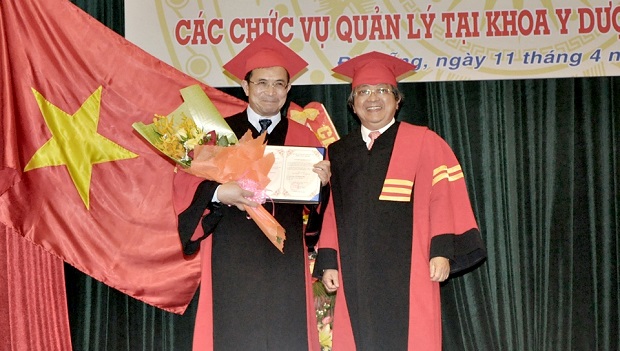 UDN Director Tran Van Nam (right) presenting flowers to professor Phi (Photo: cadn.com.vn)