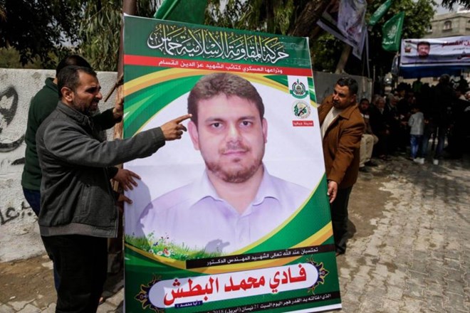 Men holding up a poster portrait of Palestinian professor and Hamas member Fadi Mohammad al-Batsh (Photo: AFP)