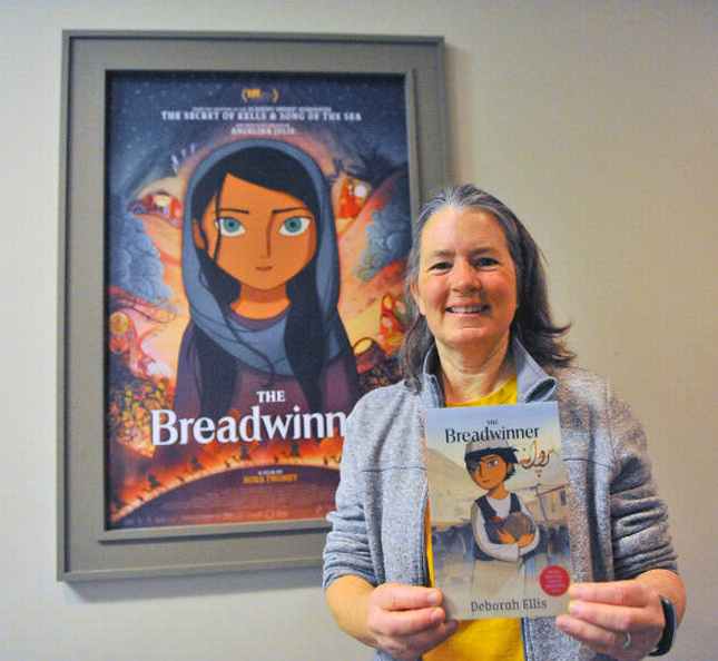 Đạo diễn Nora Twomey (trên) và nhà văn Deborah Ellis với cuốn The Breadwinner trên tay đứng trước áp-phích phim hoạt hình cùng tên.