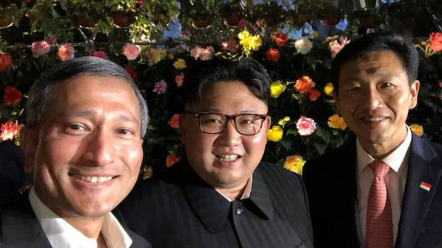 Ông Kim Jong-un tươi cười chụp ảnh khi dạo phố cùng các quan chức Singapore. (Ảnh: Twitter)