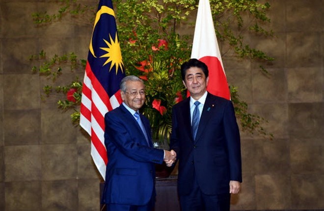 Japanese Prime Minister Shinzo Abe (R) shakes hands with his Malaysian counterpart Mahathir Mohamad (Source: thesundaily.my)