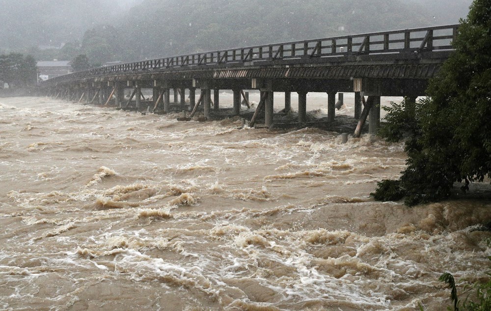 Nước lũ chảy xiết dưới cầu Togetsukyo ở Kyoto, miền Tây Nhật Bản ngày 6/7. (Nguồn: EPA/TTXVN)
