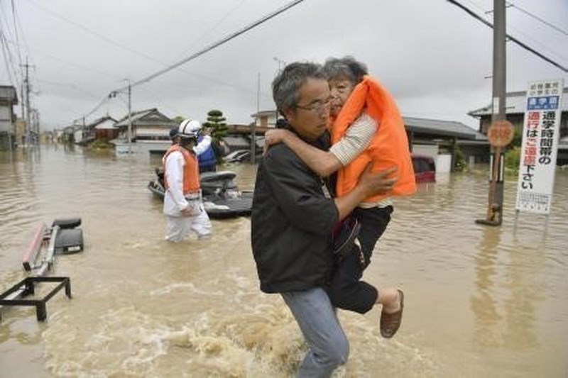 Hỗ trợ người dân sơ tán do nước lũ dâng cao tại Kurashiki, tỉnh Okayama ngày 7/7. (Nguồn: Kyodo/TTXVN)