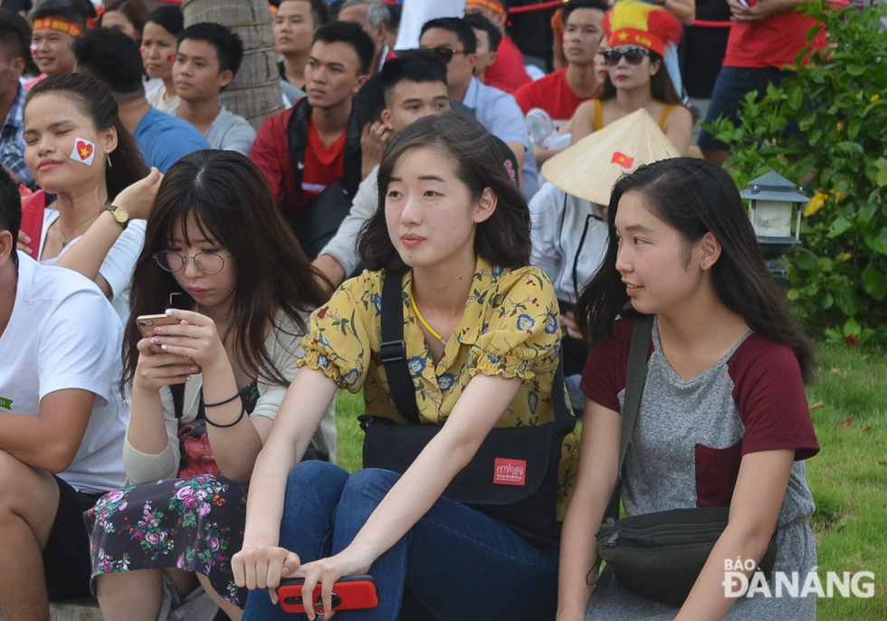 Du khách Hàn Quốc xem trận đấu giữa Việt Nam và Hàn Quốc tại một điểm chiếu bóng đá công cộng. Ảnh: XUÂN SƠN