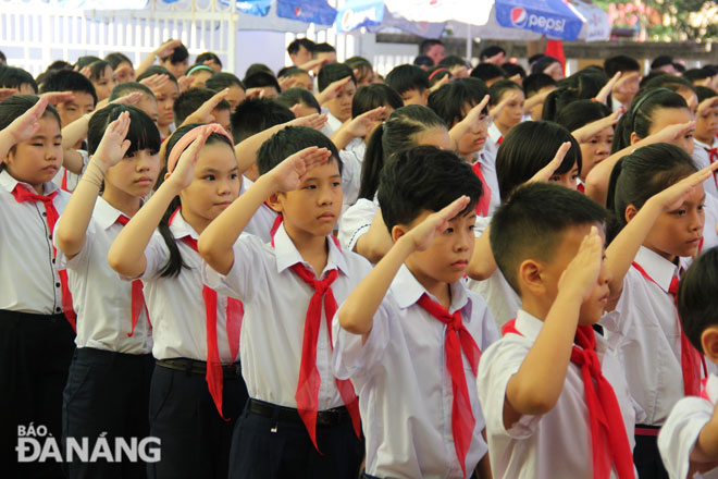 Các em học sinh lớp 6 Trường THCS Đỗ Đăng Tuyển chào cờ trong lễ khai giảng năm học mới. Ảnh: Q.KHẢI