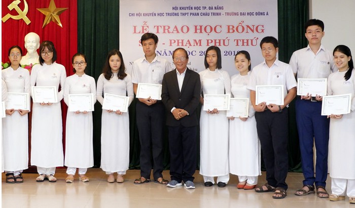 Mr Tran Ngoc Chau (in suit) and some scholarship recipients