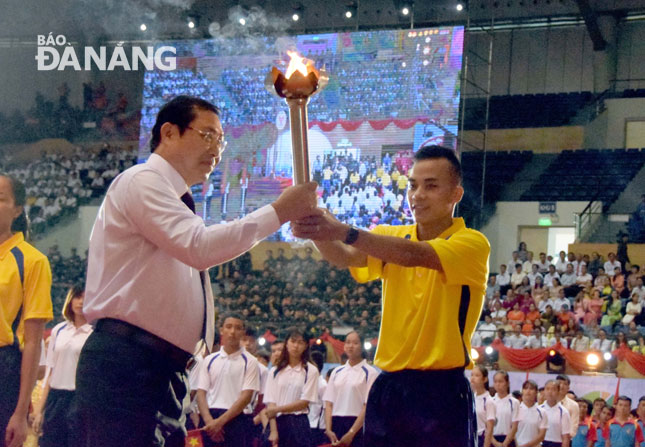 Municipal People's Committee Chairman Huynh Duc Tho receiving the festival’s torch from race walker Nguyen Thanh Ngung