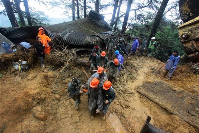 Rescuers brought bodies of victims out of a mud slide side in Baguio, the Philippines, on September 16. (Source: AFP/VNA)