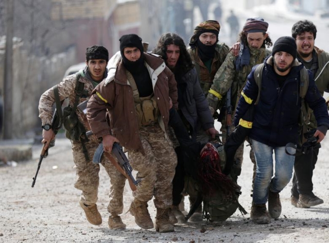Chiến binh của “Quân đội Syria Tự do” (được Thổ Nhĩ Kỳ hậu thuẫn) cùng xách một đồng đội bị thương ở Rajo, Syria, vào đầu tháng 3/2018.