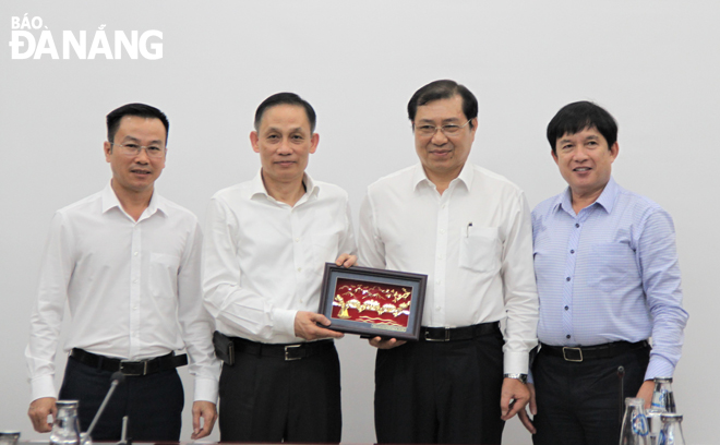 Chủ tịch UBND thành phố Huỳnh Đức Thơ  (thứ 2, phải sang) tặng quà lưu niệm Đoàn công tác Bộ Ngoại giao.  Ảnh: LAM PHƯƠNG	