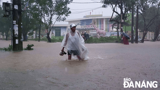 Người dân sinh sống tại khu vực Trà Na (phường Hòa Khánh Nam, quận Liên Chiểu) nhắc nhở một số xe máy không nên đi vào khu vực ngập sâu.