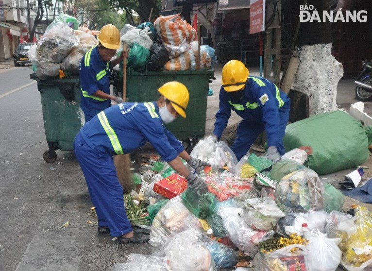 Khối lượng rác sinh hoạt phát sinh trên đường phố rất lớn. Trong ảnh: Công nhân của Xí nghiệp Môi trường Hải Châu thu gom rác ở đường Ông Ích Khiêm. Ảnh: HOÀNG HIỆP