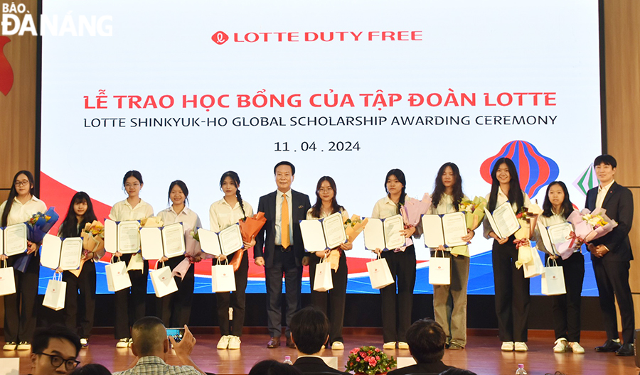 Đại diện Công ty TNHH Lotte PK Duty Free (thứ 7, trái sang) và ngoài cùng bên phải trao học bổng cho các sinh viên trường Đại học Ngoại ngữ, Đại học Đà Nẵng vượt khó, học giỏi.