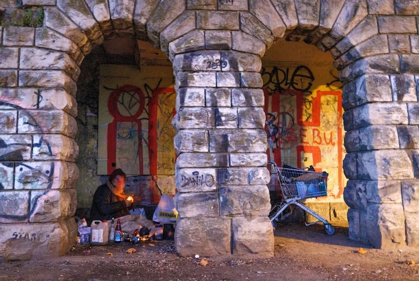 Một người vô gia cư sống dưới mái vòm tại thành phố Berlin (Đức). Ảnh: Reuters	