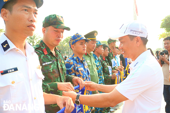 Trưởng ban Tổ chức Thành ủy Nguyễn Đình Vĩnh tặng cờ lưu niệm cho vận động viên dự giải. 