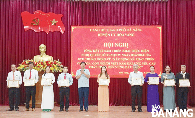 Lãnh đạo UBND huyện Hòa Vang khen thưởng cho 19 tập thể và 11 cá nhân có thành tích xuất sắc trong thực hiện Nghị quyết số 33-NQ/TW của Ban Chấp hành Trung ương Đảng (khóa XI). Ảnh: TRỌNG HÙNG