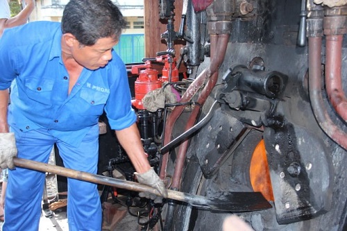 A worker at the Di An Train Company in Binh Duong Province adds coal to a 1966 steam locomotive the firm restored and will run through the Hai Van Tunnel in central Viet Nam. Photos: Vien Su/Tuoi Tre